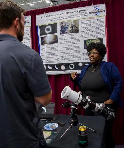 An astronomy and astrophysics student presents her capstone research at the senior design showcase.