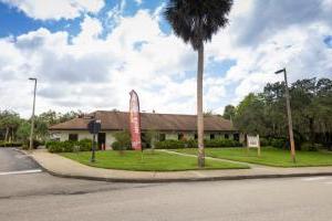 The Security Welcome Center at Florida Tech. A single-story brick building surrounded by palm trees and blue sky.